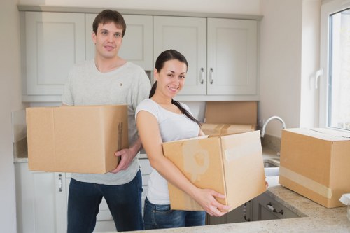 Moving team transporting sofas and cabinets during furniture removals in South Kensington